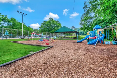 a childrens park with lots of swings slides and swimming pool