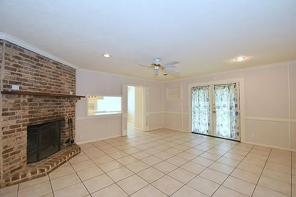 an empty room with windows and fireplace