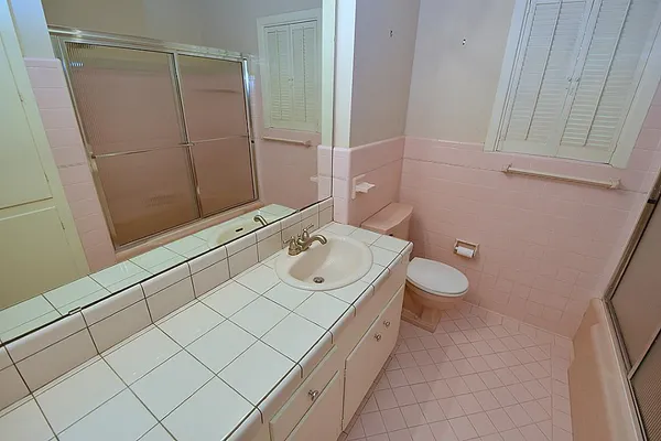 a bathroom with a sink a toilet and shower