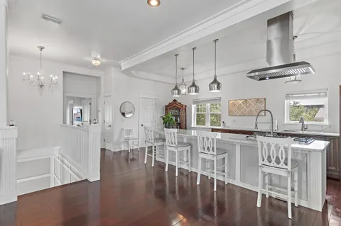 a view of a dining room with furniture a chandelier and wooden floor