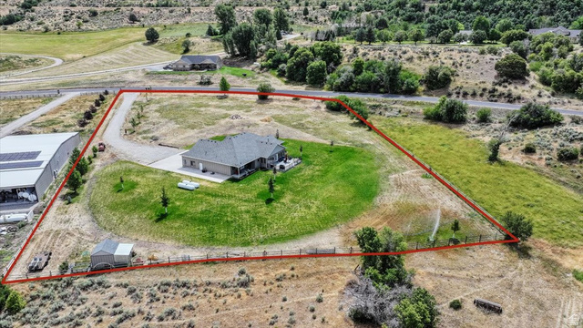 3123 East Riverdale Road Preston, ID 83263 - Photo 52 of 52 Expansive property featuring a single-story residence with a covered patio, a detached workshop, and a separate shed, all surrounded by varied landscaping