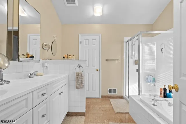 a spacious bathroom with a double vanity sink a shower and a mirror