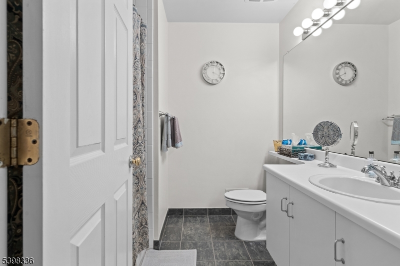 14 Minuteman Court Bernards, NJ 07920 - Photo 26 of 34 a bathroom with a toilet a sink and mirror