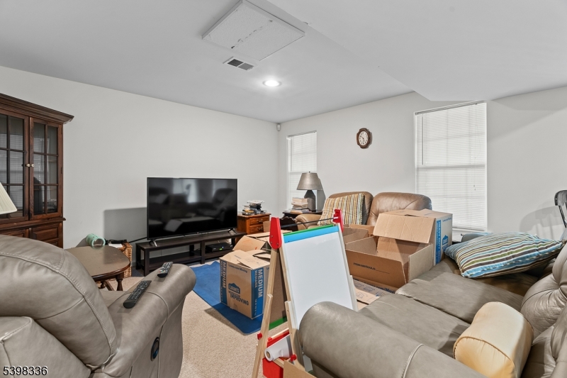 14 Minuteman Court Bernards, NJ 07920 - Photo 28 of 34 a living room with furniture and a flat screen tv