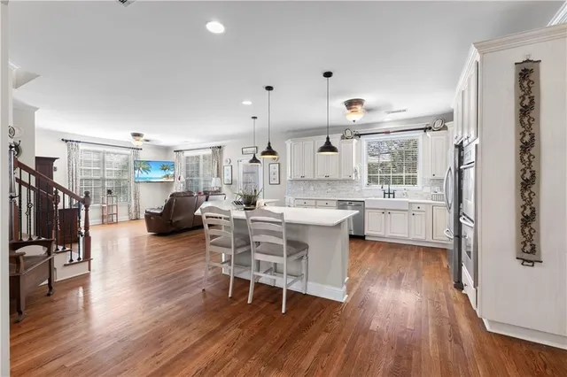 a living room with stainless steel appliances kitchen island granite countertop wooden floors and view living room
