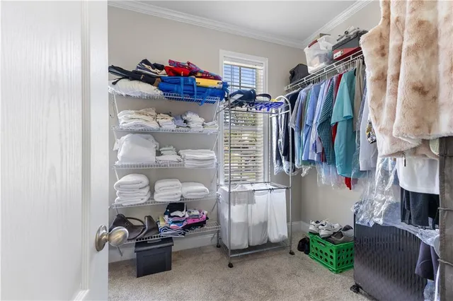 a view of walk in closet with clothes and shoes