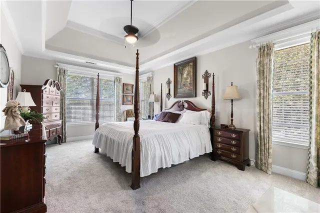a spacious bedroom with a bed chandelier and a window