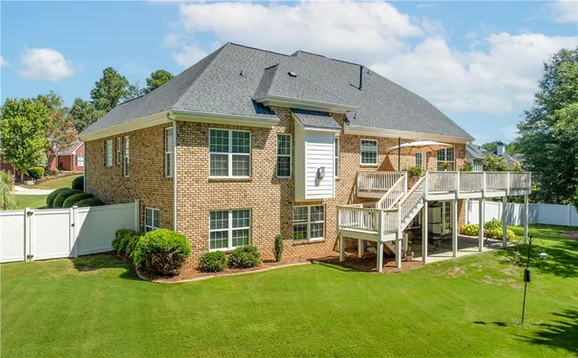 a aerial view of a house with swimming pool and large trees