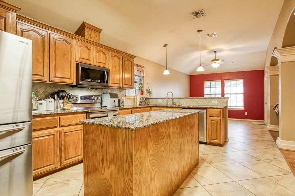 314 Hancock Odem, TX 78370 - Photo 11 of 40 a kitchen with stainless steel appliances kitchen island granite countertop a stove top oven a sink a counter top space and cabinets