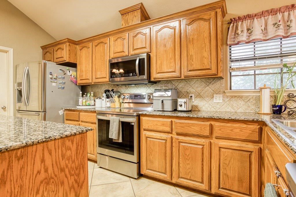 314 Hancock Odem, TX 78370 - Photo 14 of 40 a kitchen with stainless steel appliances granite countertop a sink and a microwave