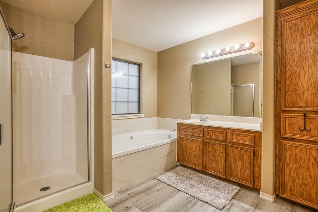 314 Hancock Odem, TX 78370 - Photo 29 of 40 a spacious bathroom with a double vanity sink a mirror and a bathtub