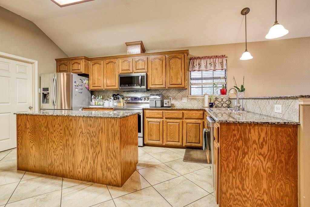 314 Hancock Odem, TX 78370 - Photo 10 of 40 a kitchen with stainless steel appliances granite countertop a sink counter space cabinets and a window