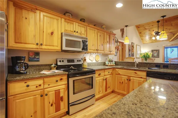 a kitchen with stainless steel appliances granite countertop a stove sink and cabinets