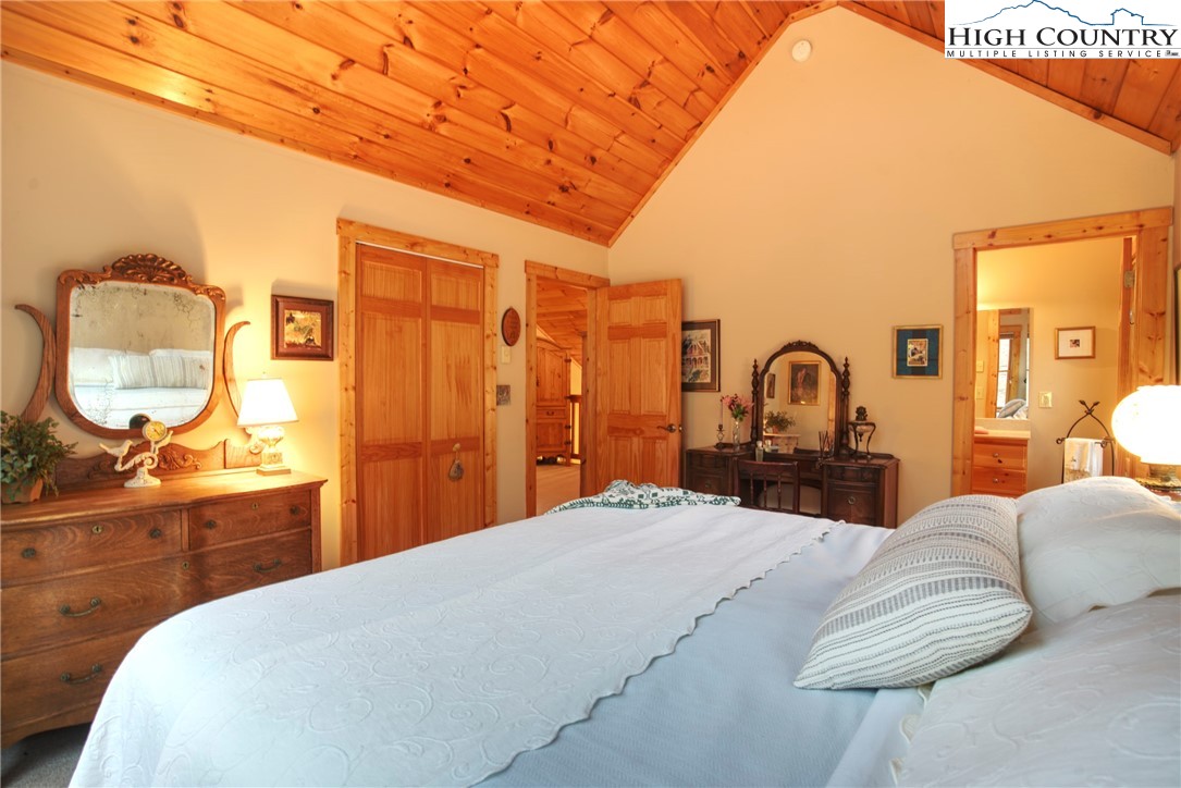 167 Rhododendron Drive Beech Mountain, NC 28604 - Photo 22 of 46 a bedroom with a bed a mirror and dresser