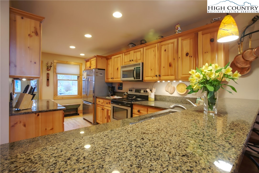 167 Rhododendron Drive Beech Mountain, NC 28604 - Photo 3 of 46 a kitchen with stainless steel appliances granite countertop a stove a sink and a microwave