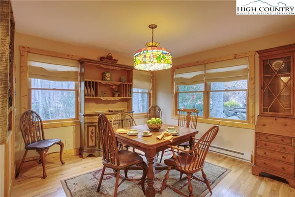 a view of a dining room with furniture a chandelier and wooden floor