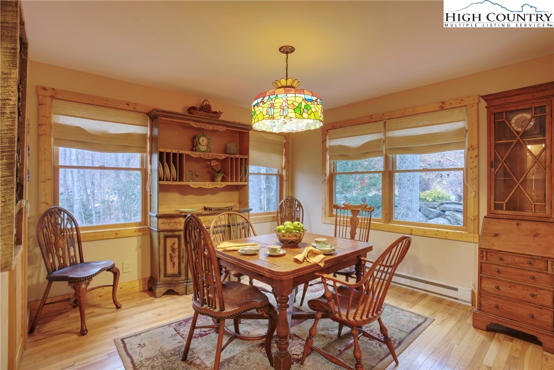 167 Rhododendron Drive Beech Mountain, NC 28604 - Photo 4 of 46 a view of a dining room with furniture a chandelier and wooden floor