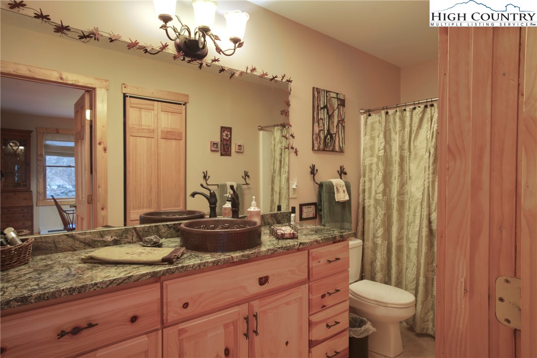 167 Rhododendron Drive Beech Mountain, NC 28604 - Photo 6 of 46 a bathroom with a granite countertop sink toilet and shower