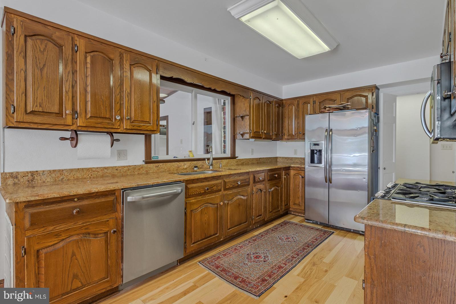 710 Train Lane Heathsville, VA 22473 - Photo 12 of 59 a kitchen with stainless steel appliances granite countertop a refrigerator a sink dishwasher and wooden cabinets with wooden floor