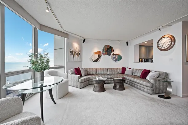 a living room with furniture a clock and a potted plant