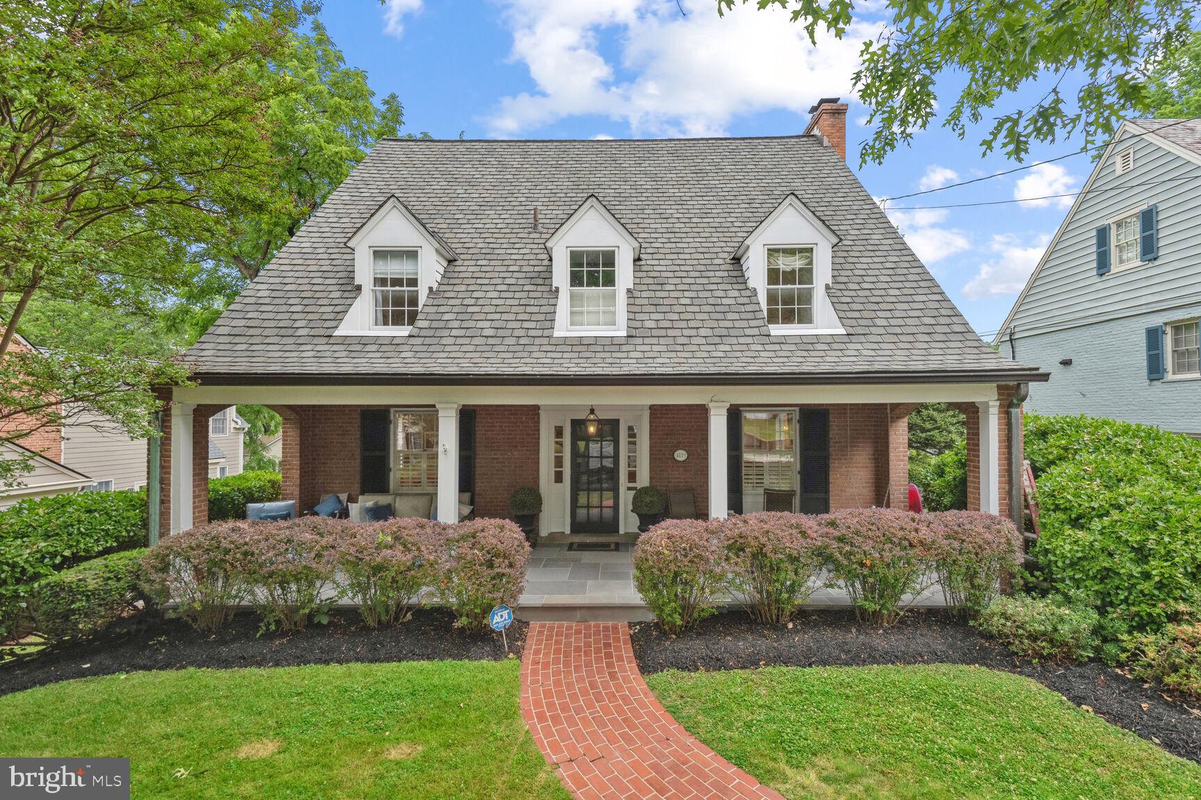 a front view of a house with a yard and potted plants