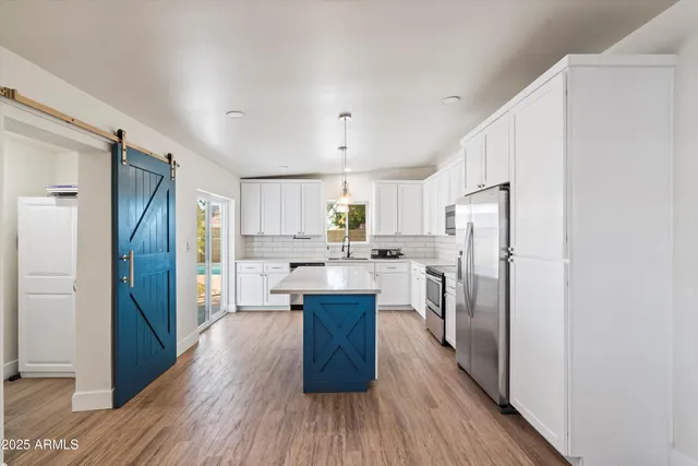 a kitchen with stainless steel appliances a refrigerator and a stove top oven