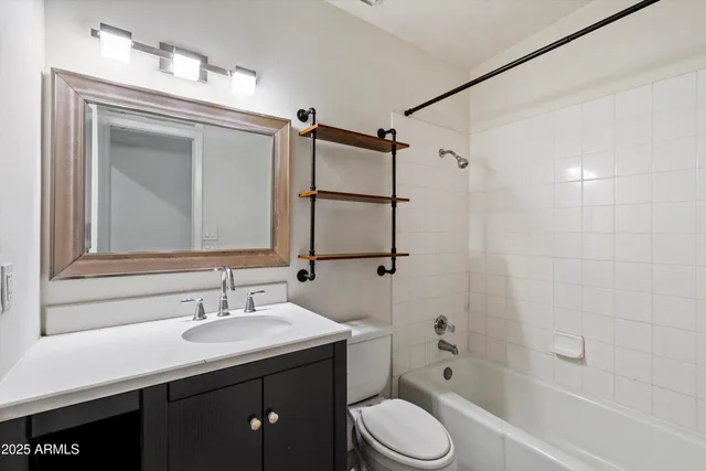 a bathroom with a sink a toilet a mirror and shower
