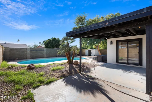 a view of backyard with wooden fence and a porch