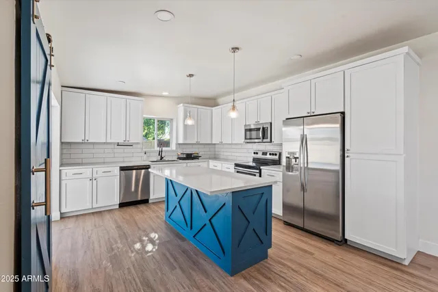 a kitchen with kitchen island granite countertop a sink refrigerator and cabinets