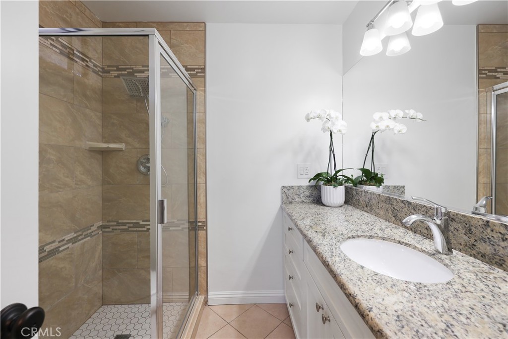 454 Seaward Road Corona del Mar, CA 92625 - Photo 11 of 33 a bathroom with a granite countertop sink a mirror and shower
