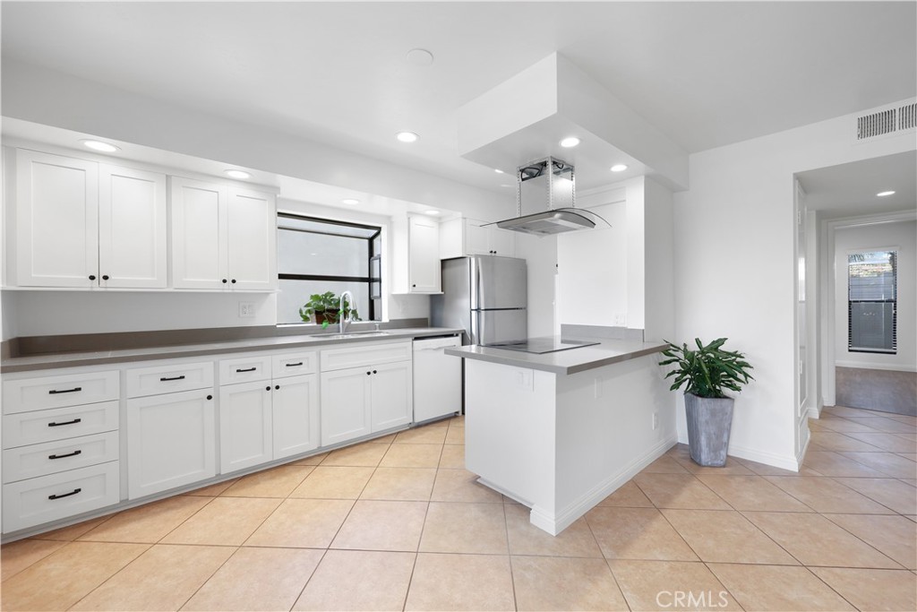 454 Seaward Road Corona del Mar, CA 92625 - Photo 6 of 33 a kitchen with granite countertop white cabinets and white appliances