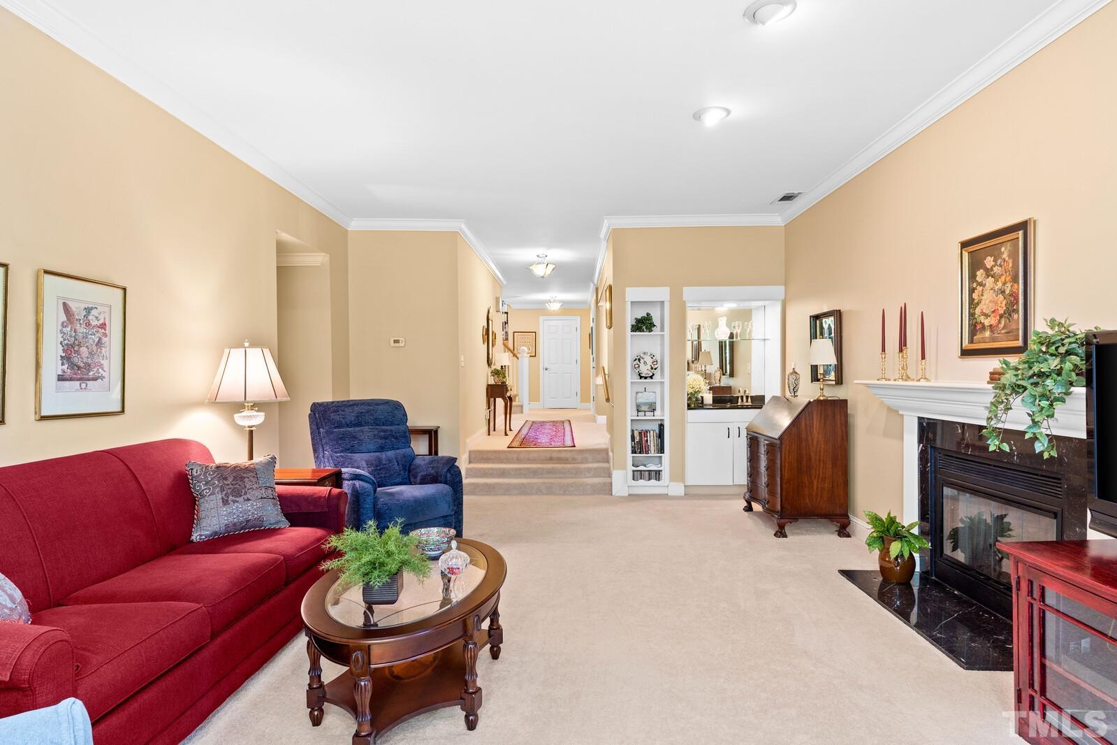 7500 Cadbury Court, Unit 101 Raleigh, NC 27615 - Photo 16 of 41 a living room with furniture a fireplace and a large mirror