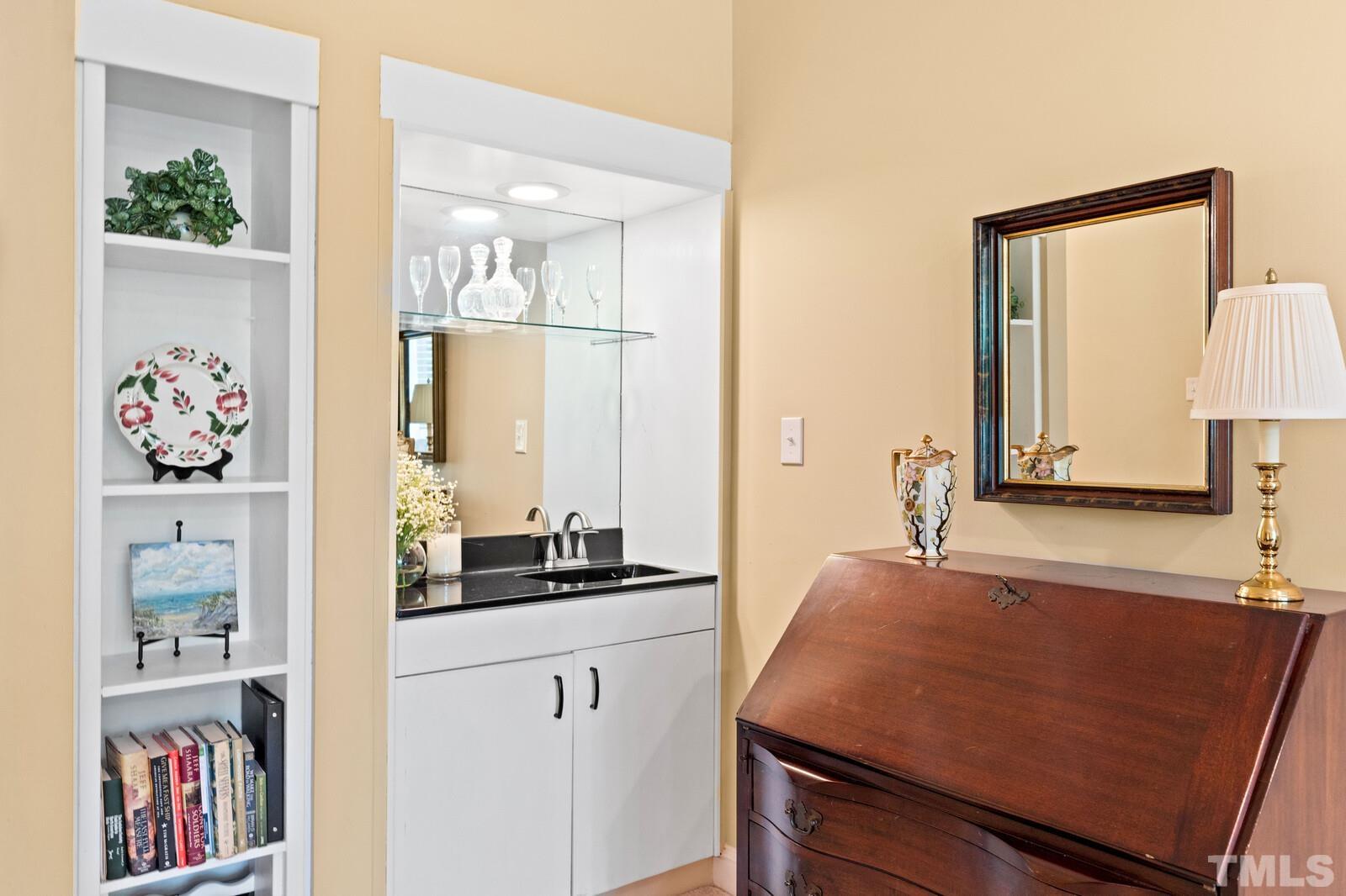 7500 Cadbury Court, Unit 101 Raleigh, NC 27615 - Photo 17 of 41 a bathroom with a sink a mirror and painting on the wall