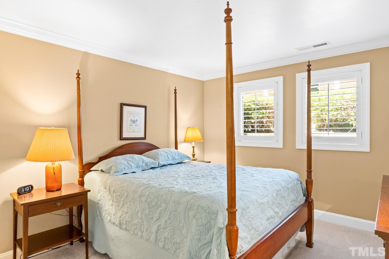 7500 Cadbury Court, Unit 101 Raleigh, NC 27615 - Photo 23 of 41 a bedroom with a bed and lamp next to a window