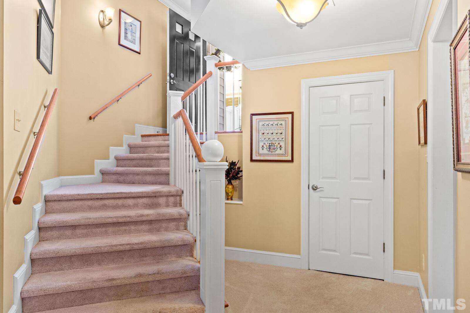 7500 Cadbury Court, Unit 101 Raleigh, NC 27615 - Photo 4 of 41 a view of staircase with lots of frames on wall and a window