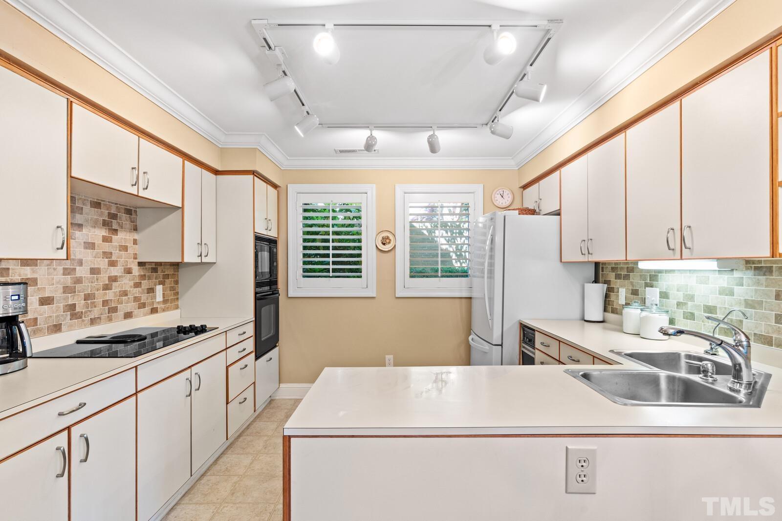 7500 Cadbury Court, Unit 101 Raleigh, NC 27615 - Photo 5 of 41 a kitchen that has a sink and a stove top oven
