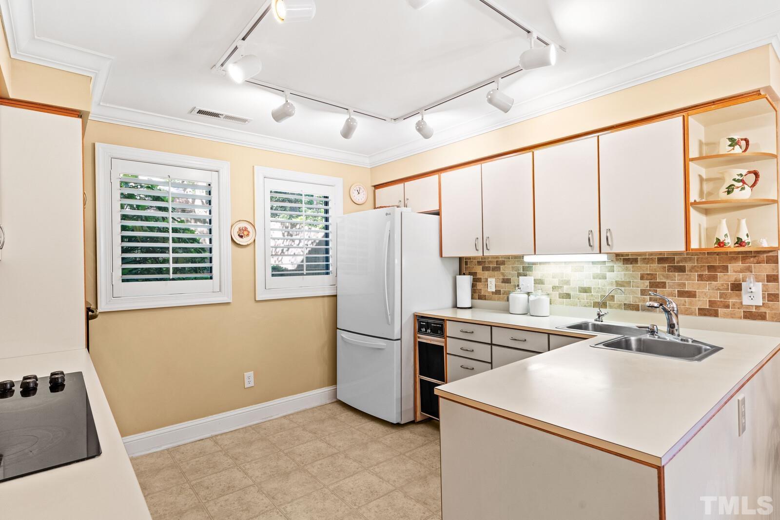 7500 Cadbury Court, Unit 101 Raleigh, NC 27615 - Photo 6 of 41 a kitchen with a sink a refrigerator and cabinets
