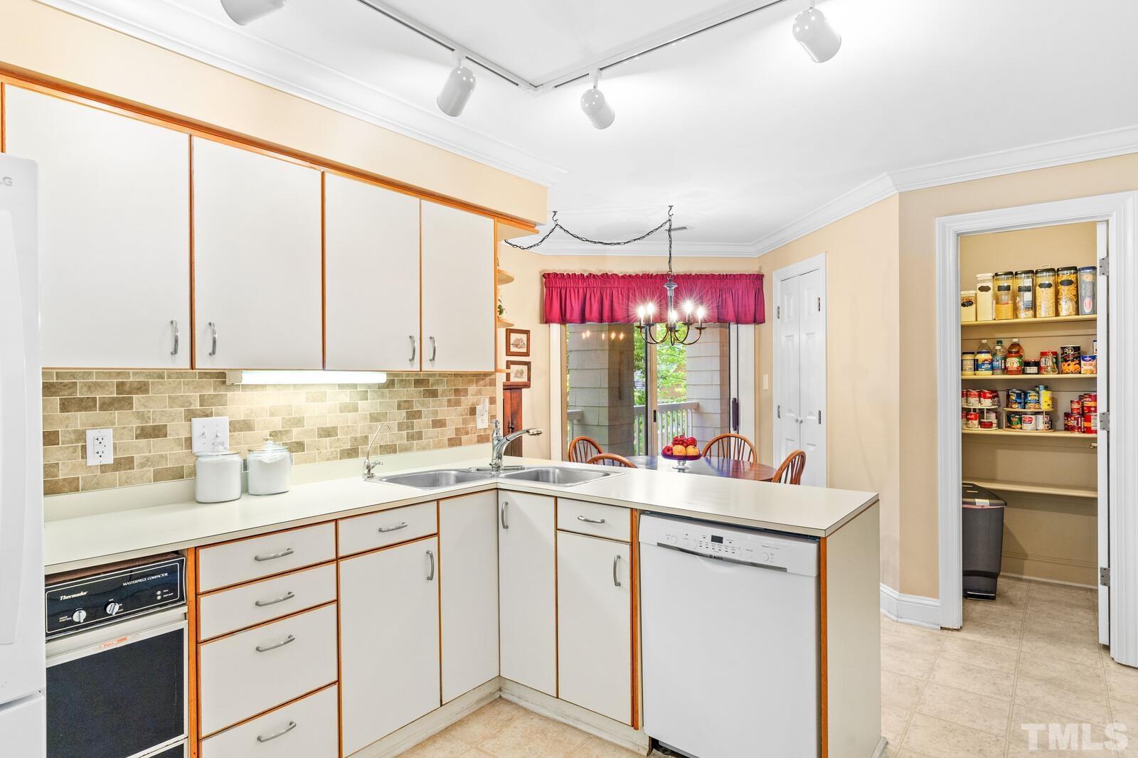 7500 Cadbury Court, Unit 101 Raleigh, NC 27615 - Photo 8 of 41 a kitchen with a sink dishwasher a stove and white cabinets with wooden floor