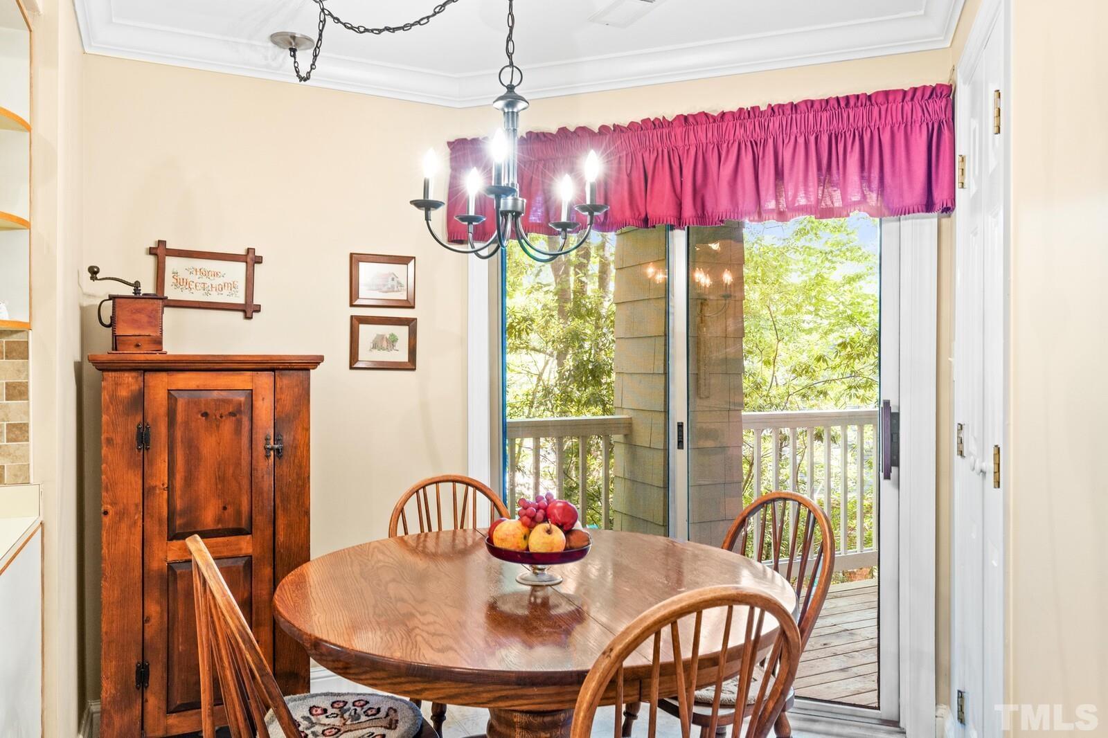 7500 Cadbury Court, Unit 101 Raleigh, NC 27615 - Photo 9 of 41 a dining room with furniture a chandelier and window