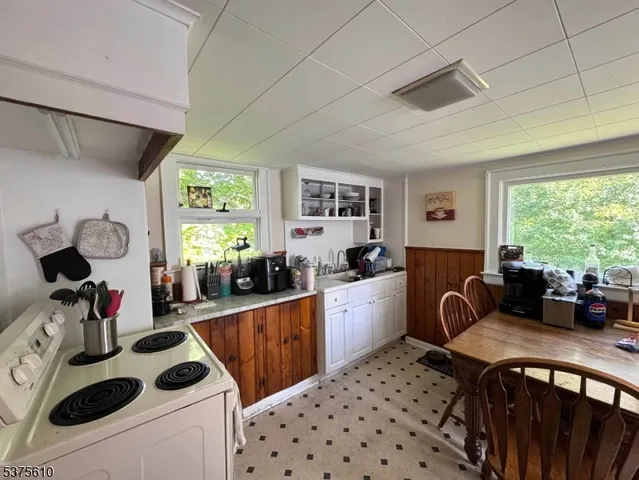 a kitchen with a sink a stove a refrigerator and white cabinets
