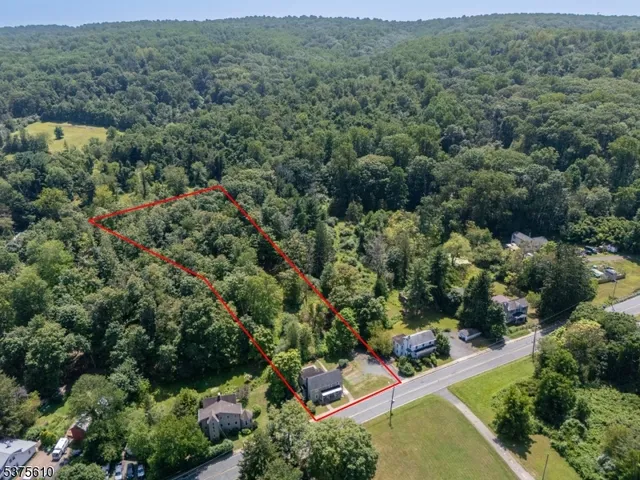 an aerial view of residential house with outdoor space and trees all around
