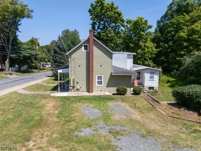 a view of a house with a yard and large tree