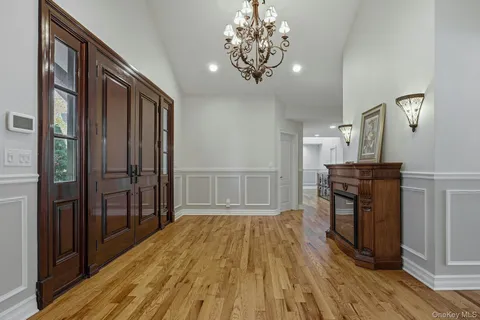 a view of a hallway with wooden floor and a kitchen