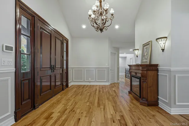 a view of a hallway with wooden floor and a kitchen