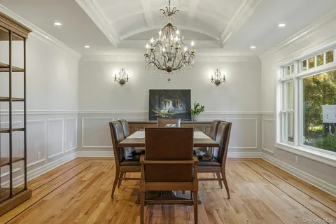 a view of a dining room with furniture a chandelier and wooden floor