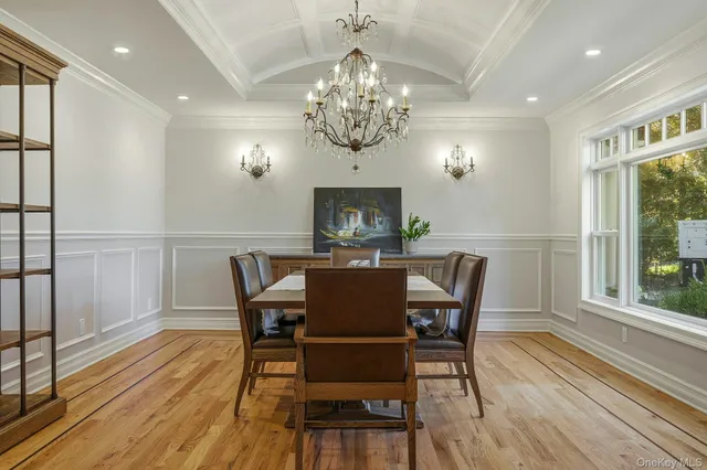 a view of a dining room with furniture a chandelier and wooden floor