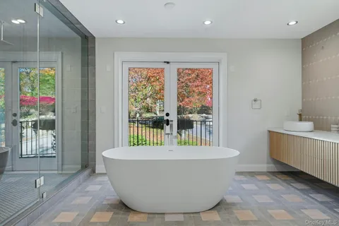 a white bath tub sitting in a bathroom next to a window