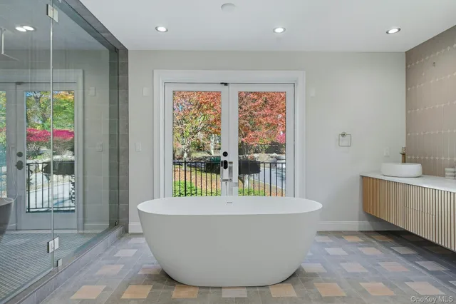 a white bath tub sitting in a bathroom next to a window
