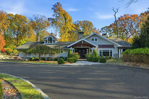 a front view of a house with a yard and potted plants