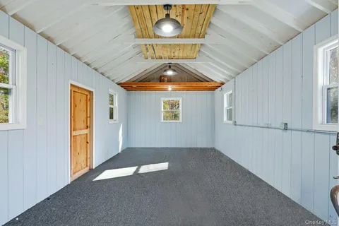 an empty room with a fan and windows